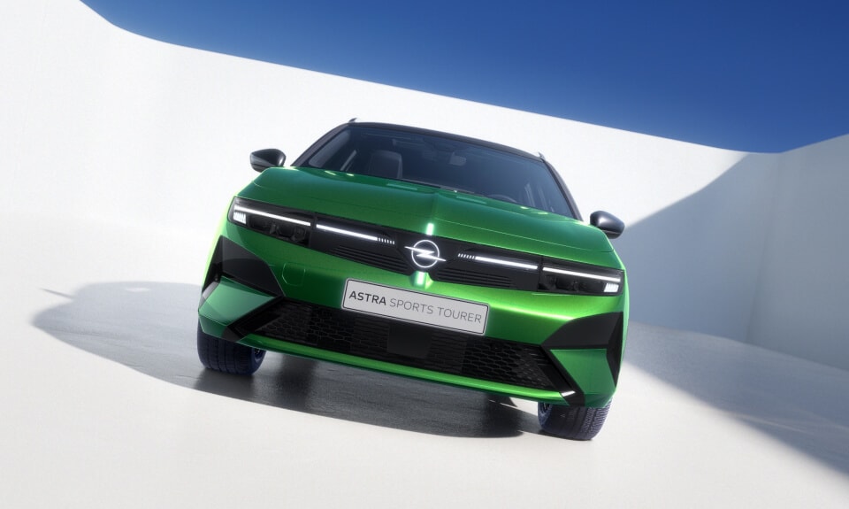 Vista laterale posteriore di un’Opel Astra Sports Tourer verde con cerchi in lega e tetto neri