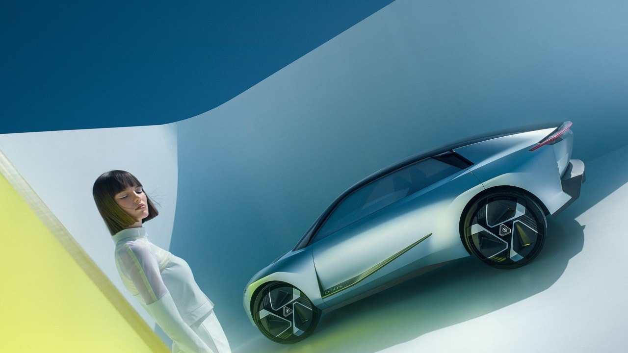 Vista frontale di Opel Experimental argentata con una donna accanto.