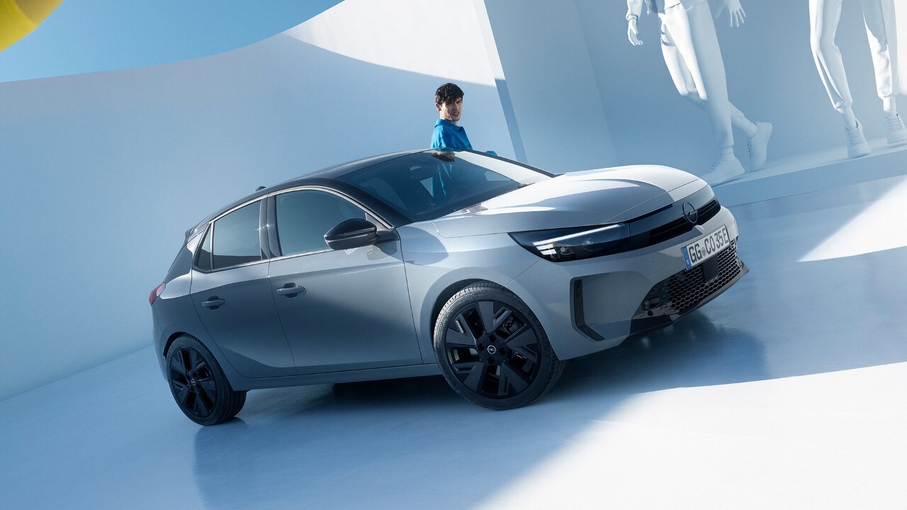 Vista frontale di una Opel Corsa Electric grigia con cerchi in lega e tetto neri