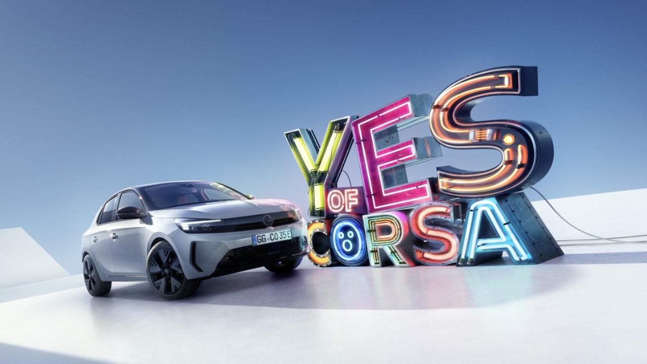Vista laterale della Opel Corsa Electric grigia con le lettere "Yes of Corsa